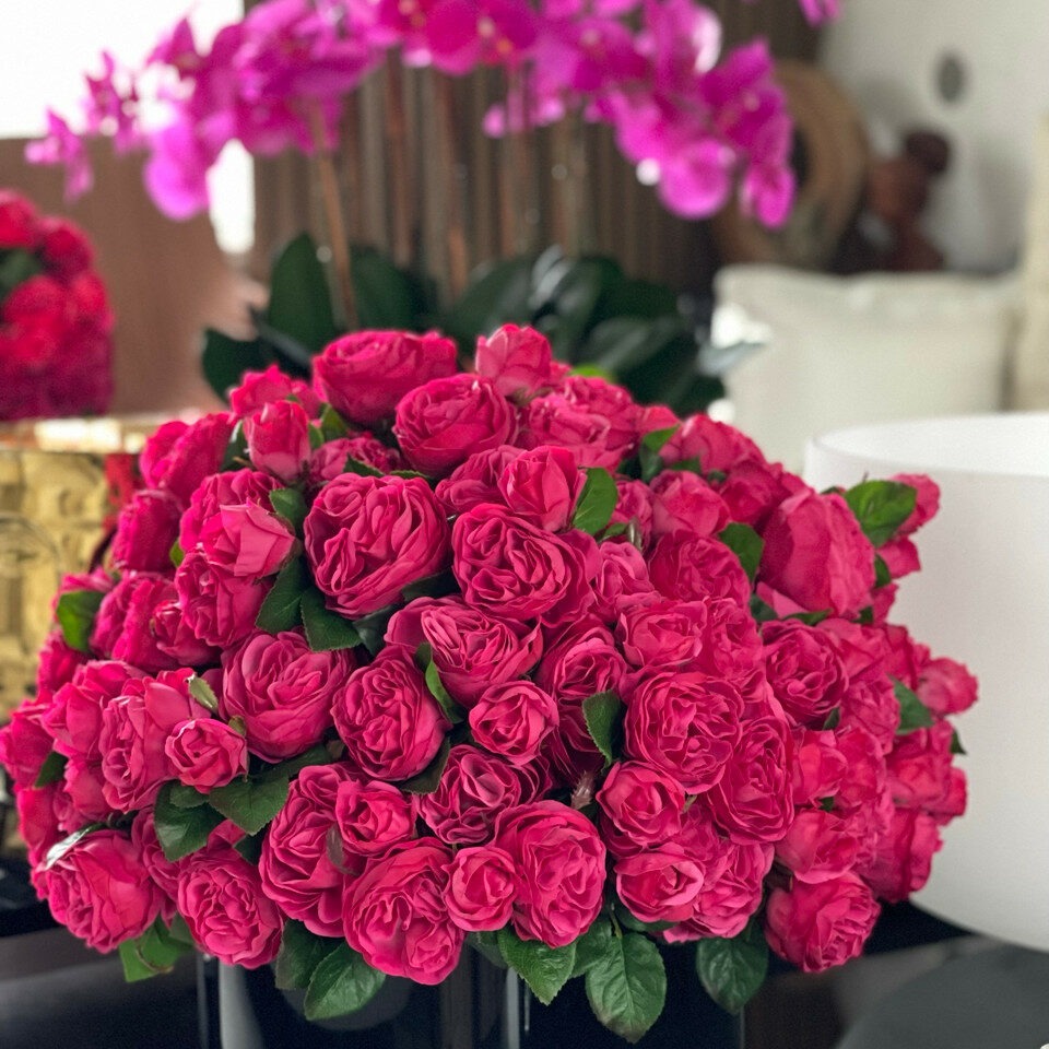 Dark pink English roses in a black glass vase.