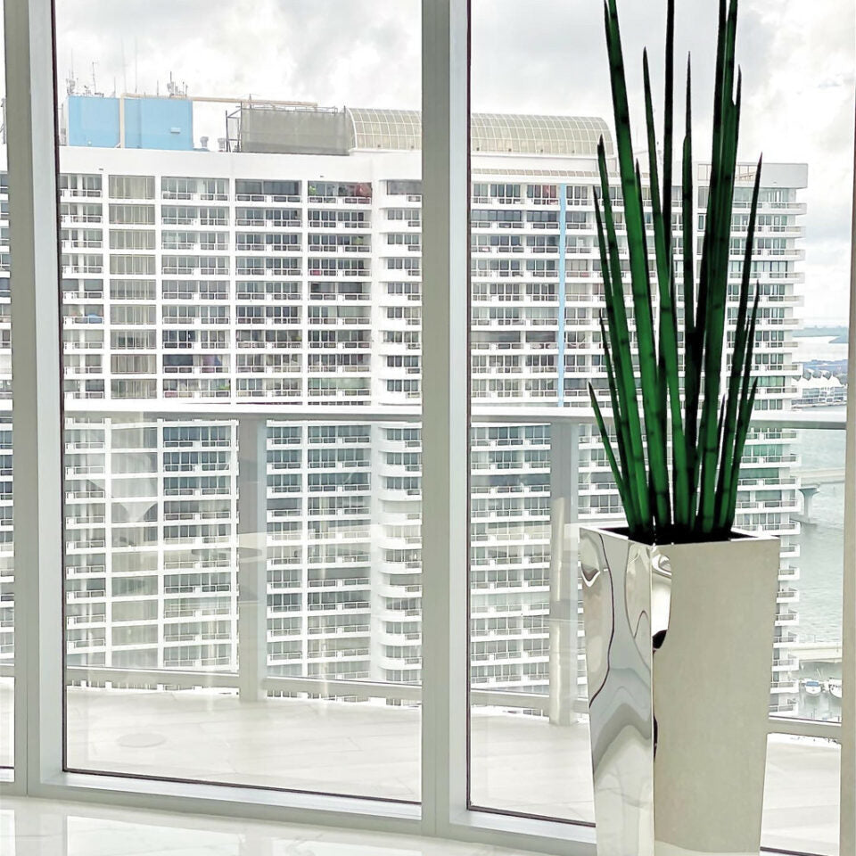 Stainless steel cube-shaped vase with snake grass.